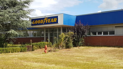 Aufnahme einer Industriehalle, über dem Eingang ist das Logo von Goodyear angebracht